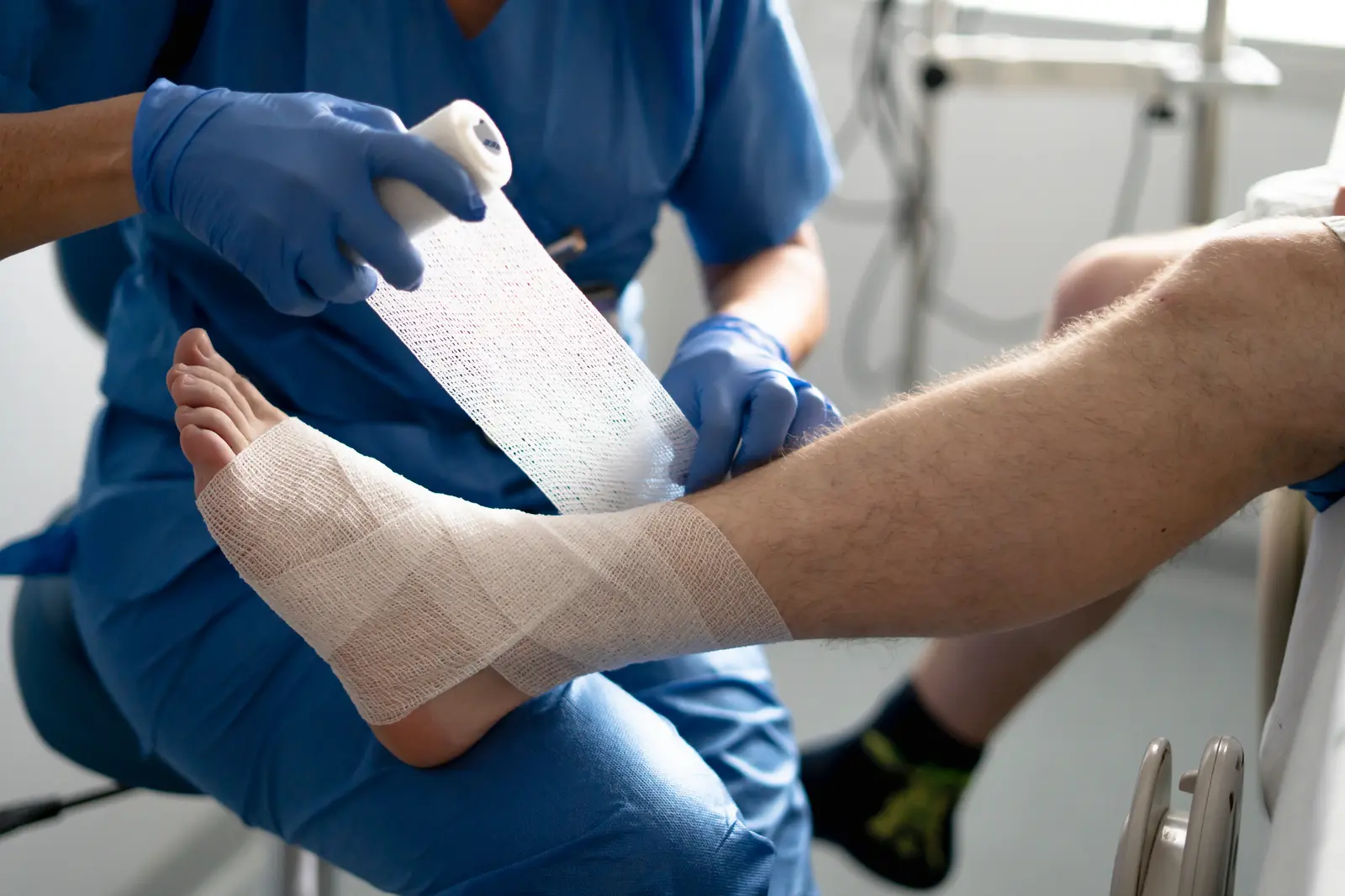 Wound care specialist applying a bandage to a patient's foot and ankle
